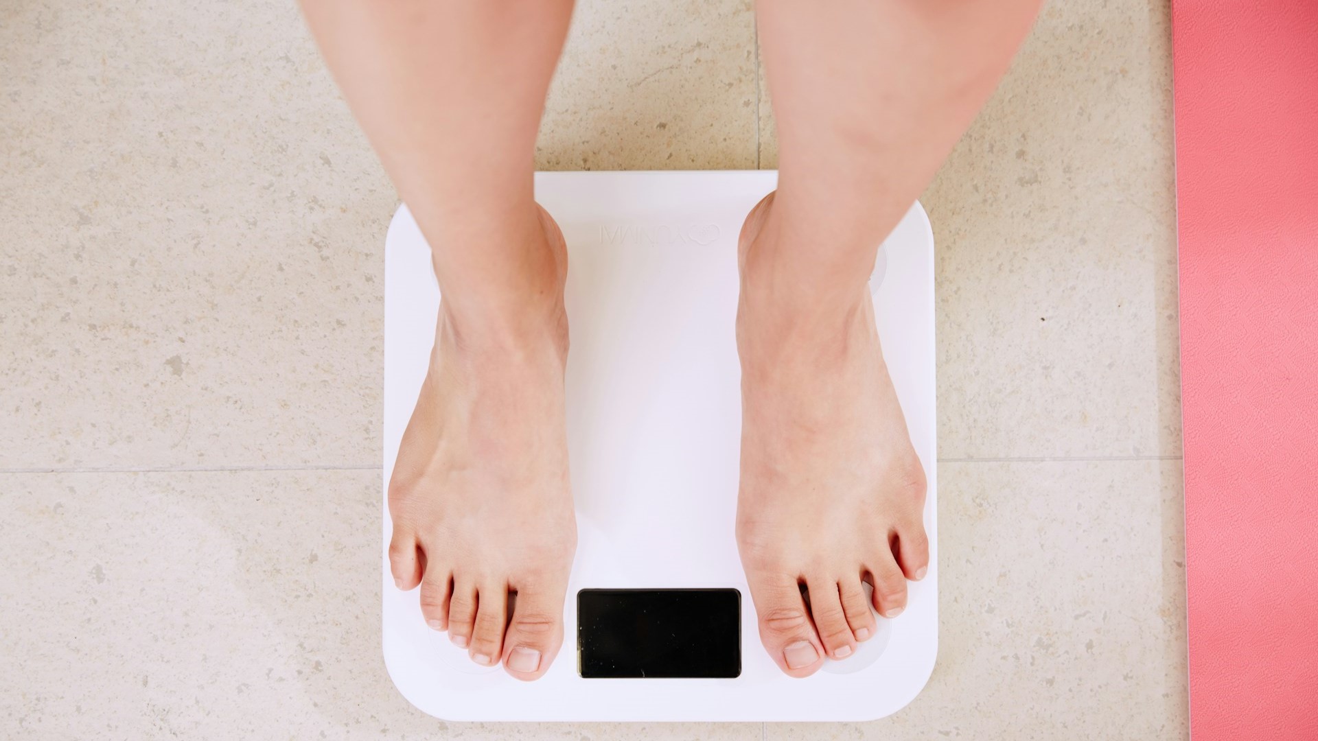Voeten op een weegschaal tijdens het afvallen zonder spiermassa te verliezen