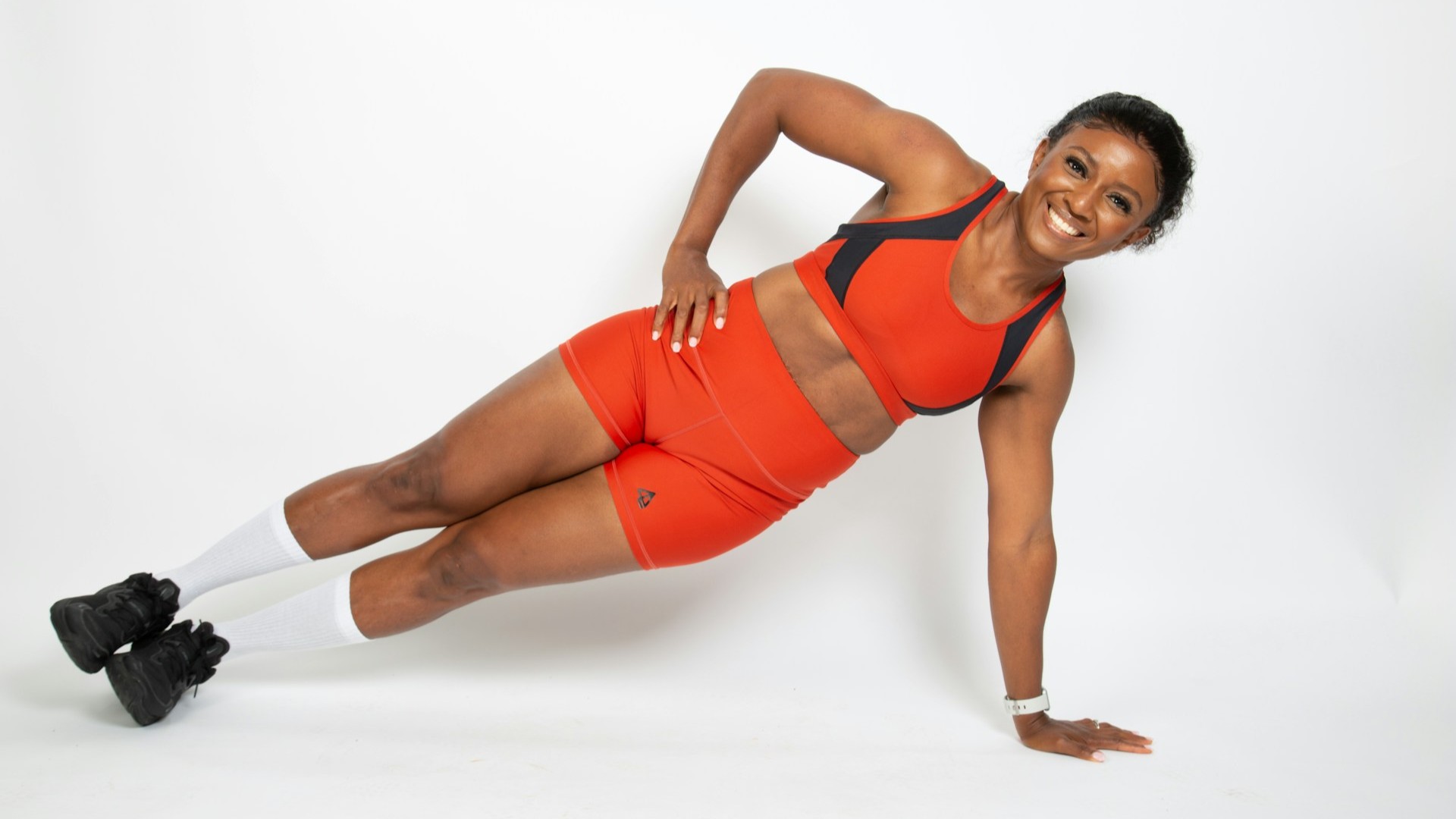 Vrouw doet een zijwaartse plank om haar belastbaarheid en corekracht te trainen