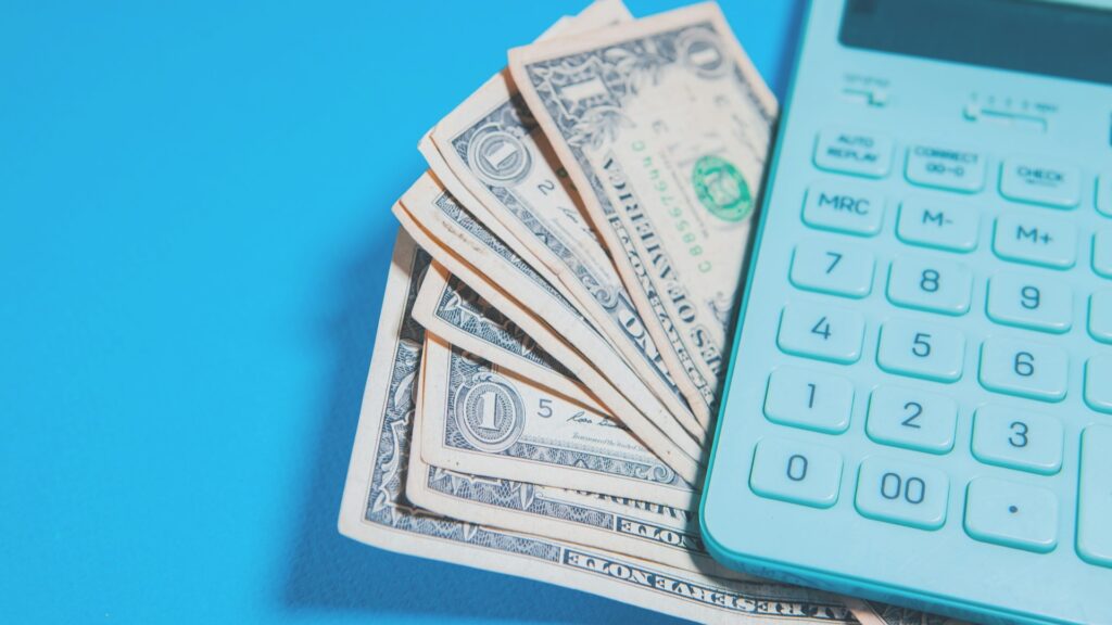 Internationale payroll berekening met dollarbiljetten en rekenmachine voor salarisadministratie