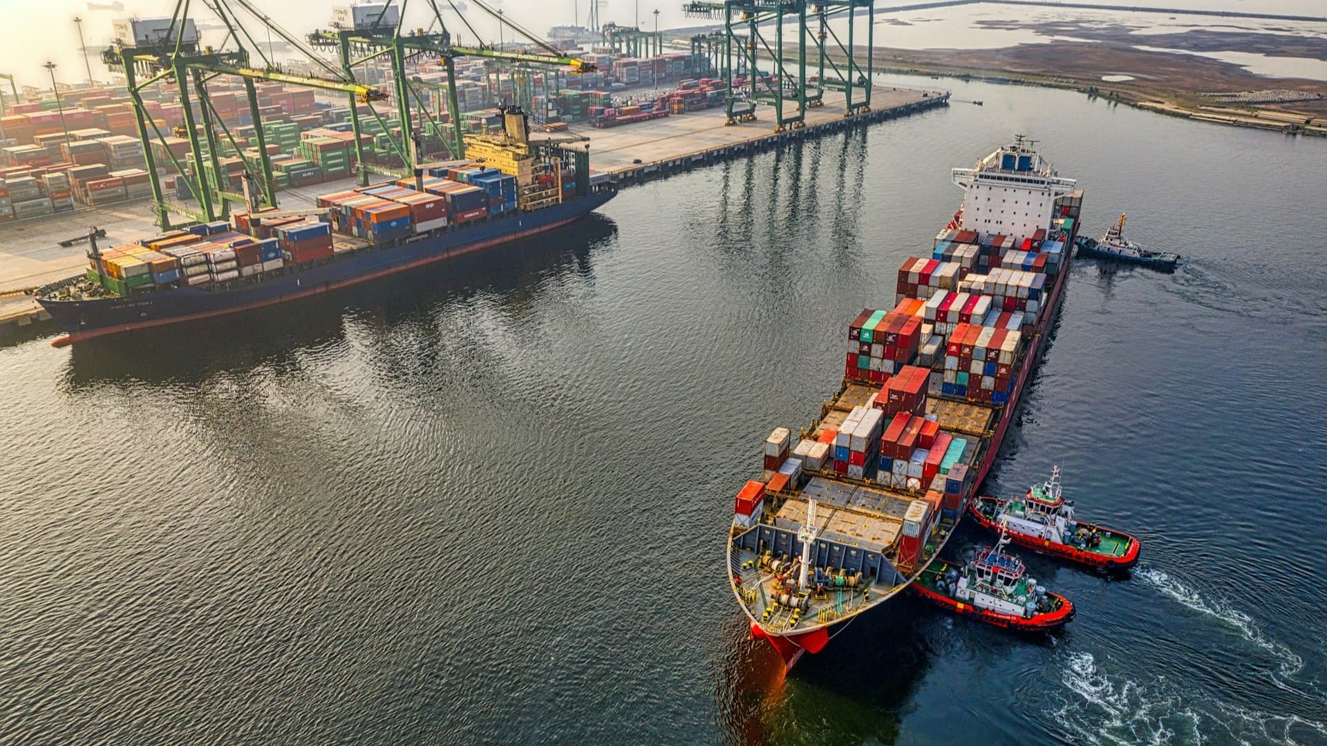 Containerschip met sleepboten arriveert bij terminal voor container lossen haven